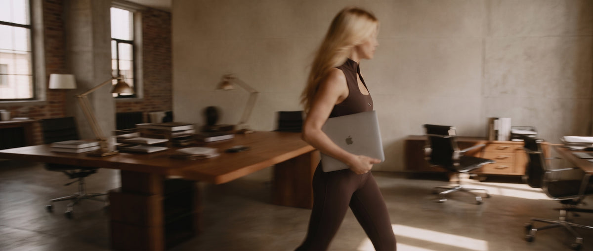 Woman in The Strategy Top and The Execution Legging by Delikate Beast walking through a loft office